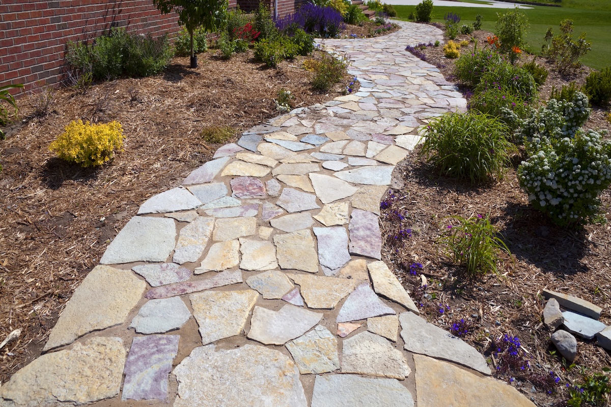 A long DIY garden path made with natural stone.