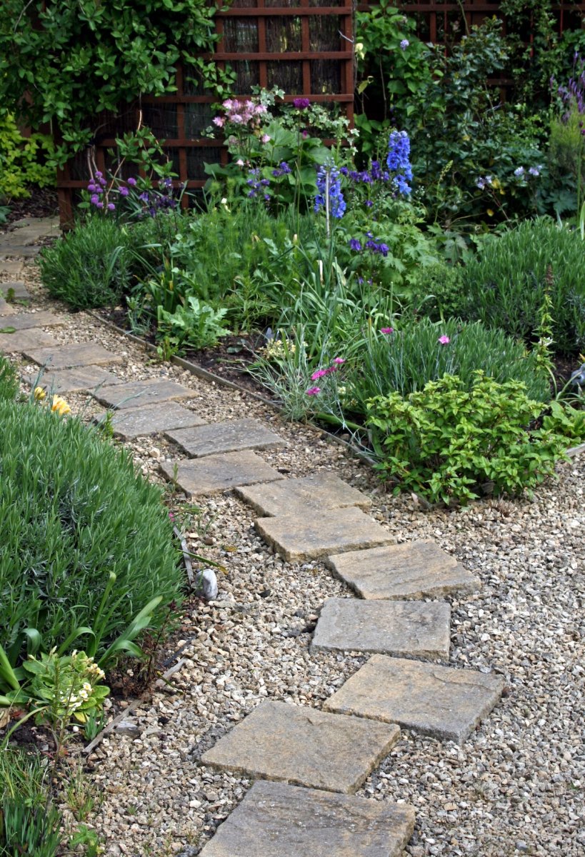 A stone and pea gravel garden path outside of a suburban home.