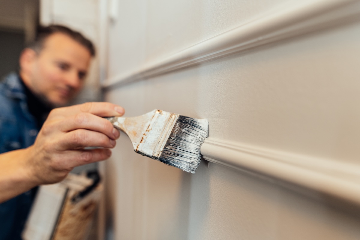 A DIYer painting trim and walls the same color.