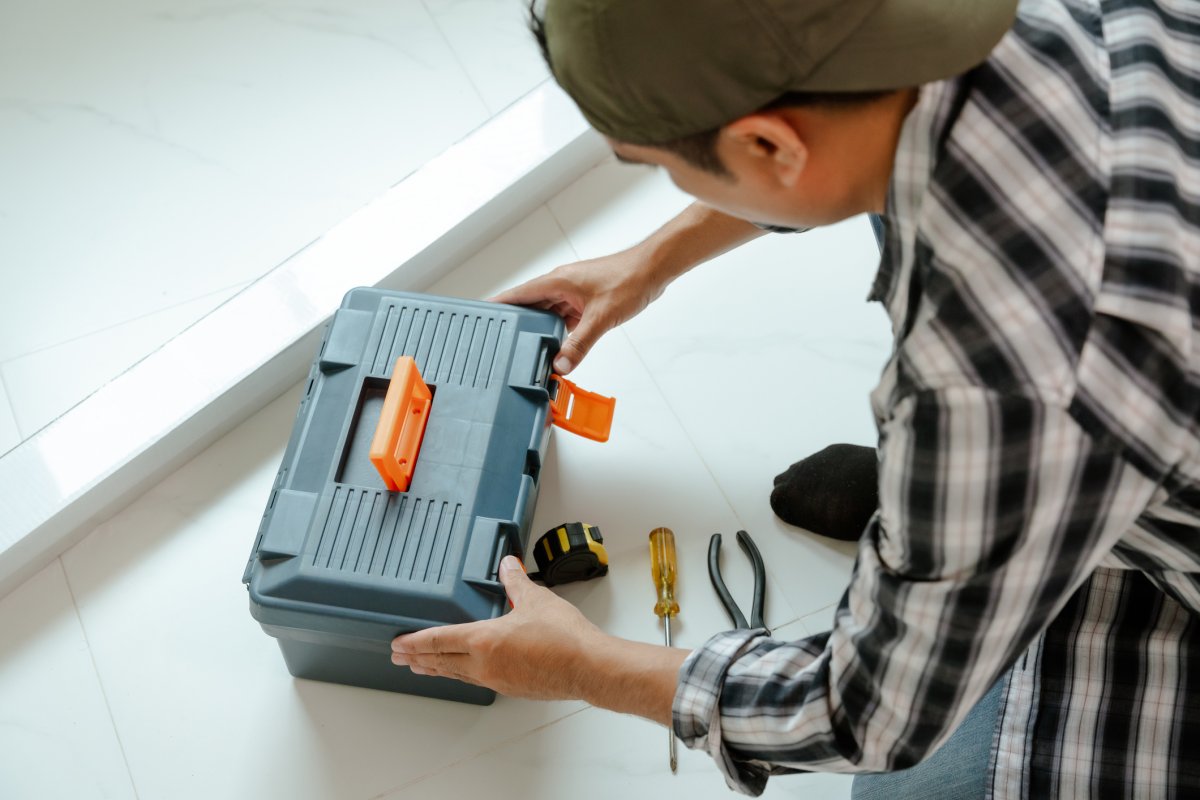 A man is opening a toolbox at his new home.