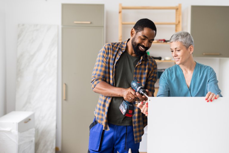 Couple using a drill without proper PPE.