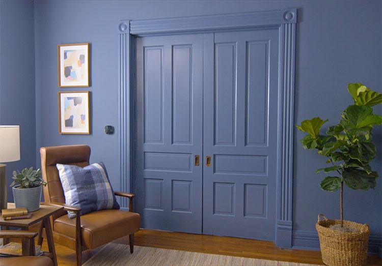 A blue room with the same color trim and doors in a home office.