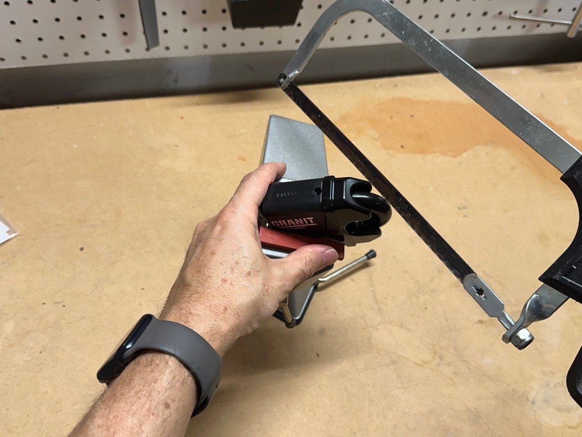 A person trying to open one of the best padlock models with a saw