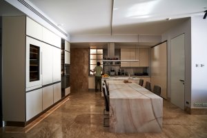The interior of a large and beautiful marble kitchen with a panel ready seamless refrigerator.