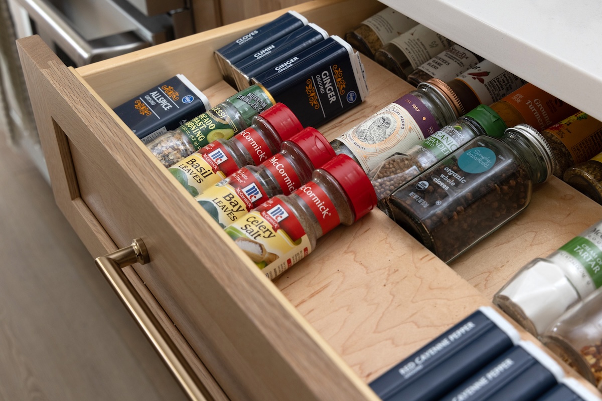 A spice rack in a cabinet drawer.