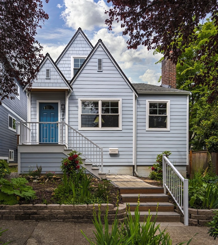 A blue home with a newly renovated front porch.