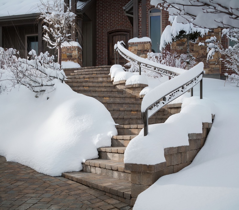 Snow-covered steps lead up to a home's front door.