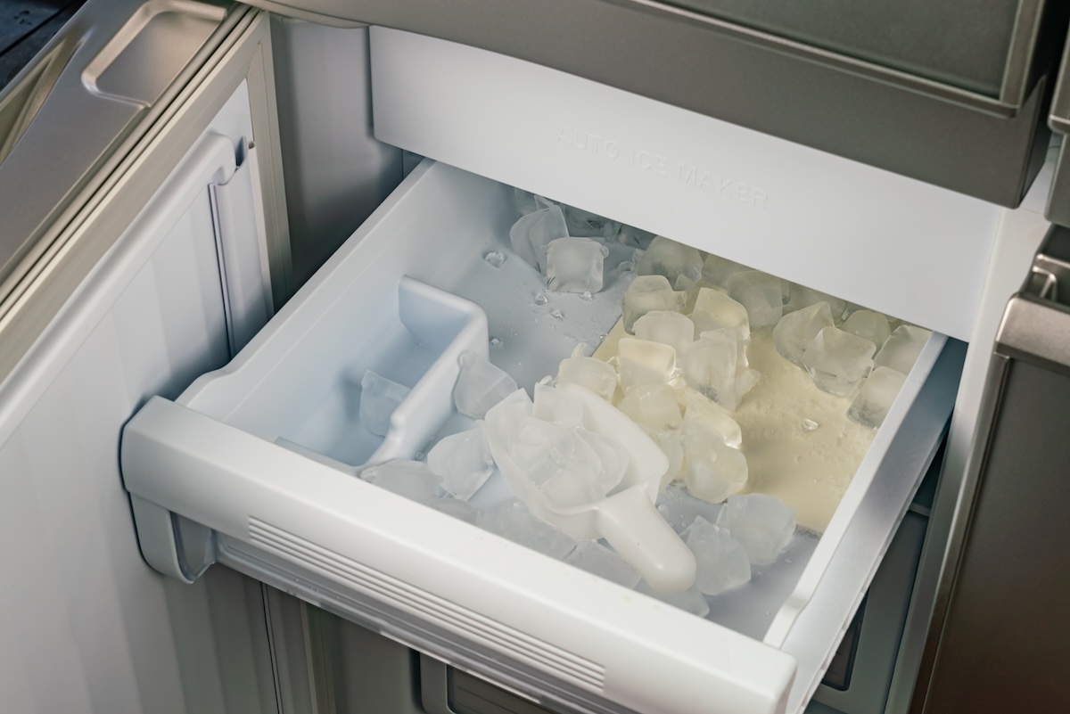 The inside of a discolored and dirty ice cube maker.