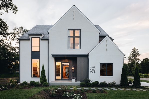 Modern light grey house with black window frames and house number spelled out.