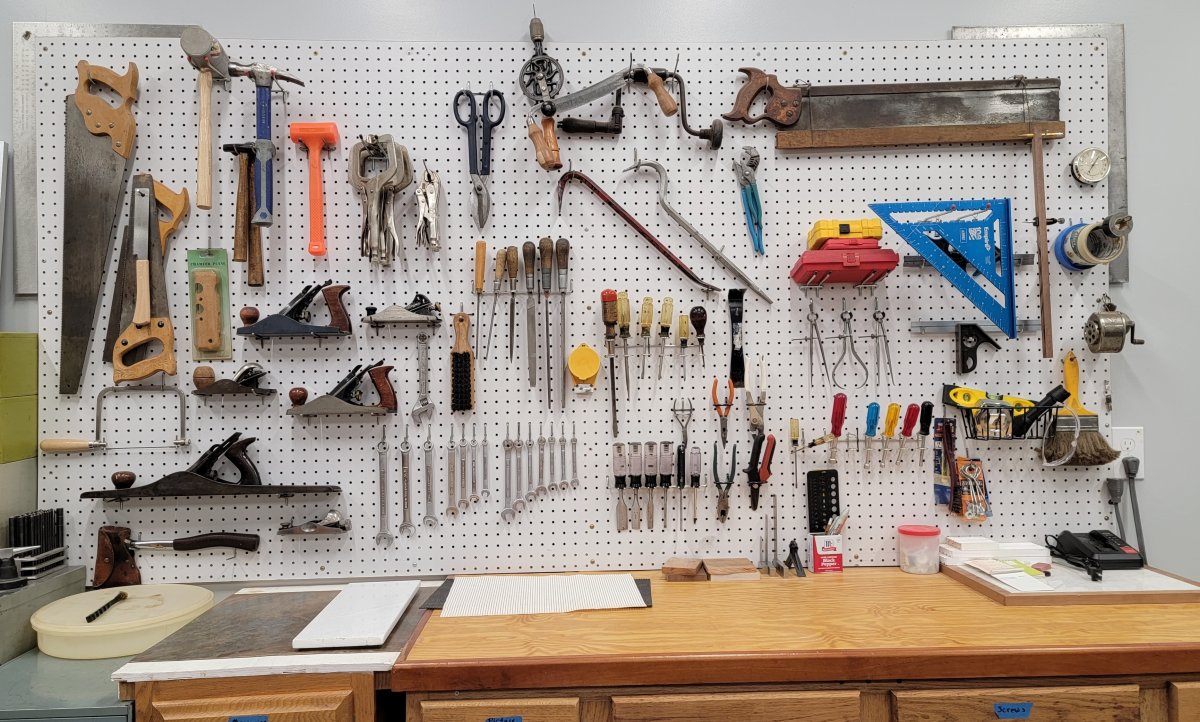 Pegboard storage wall in a garage filled with tools.
