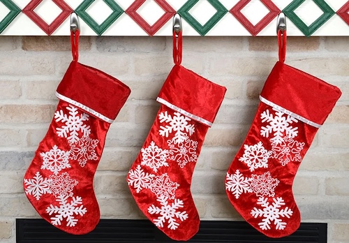 Command 5lb forever hooks holding three festive Christmas stockings on a mantel.