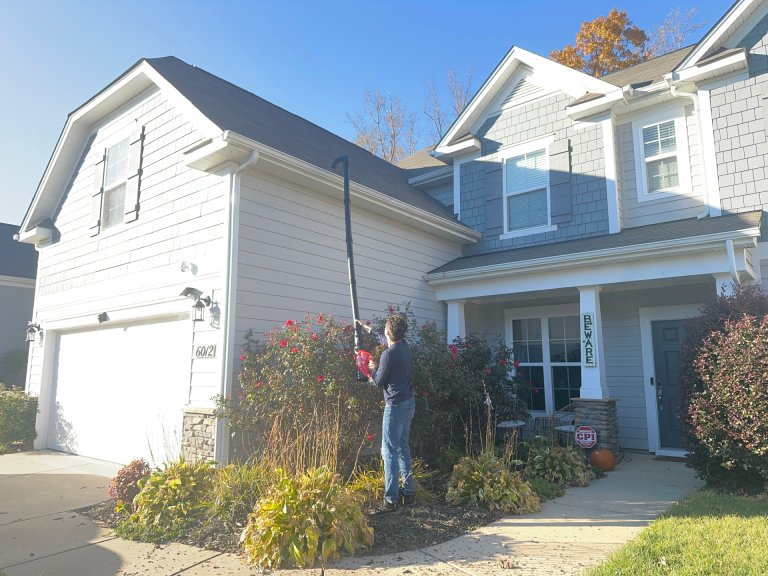 A man cleaning gutter with one of the best gutter cleaners