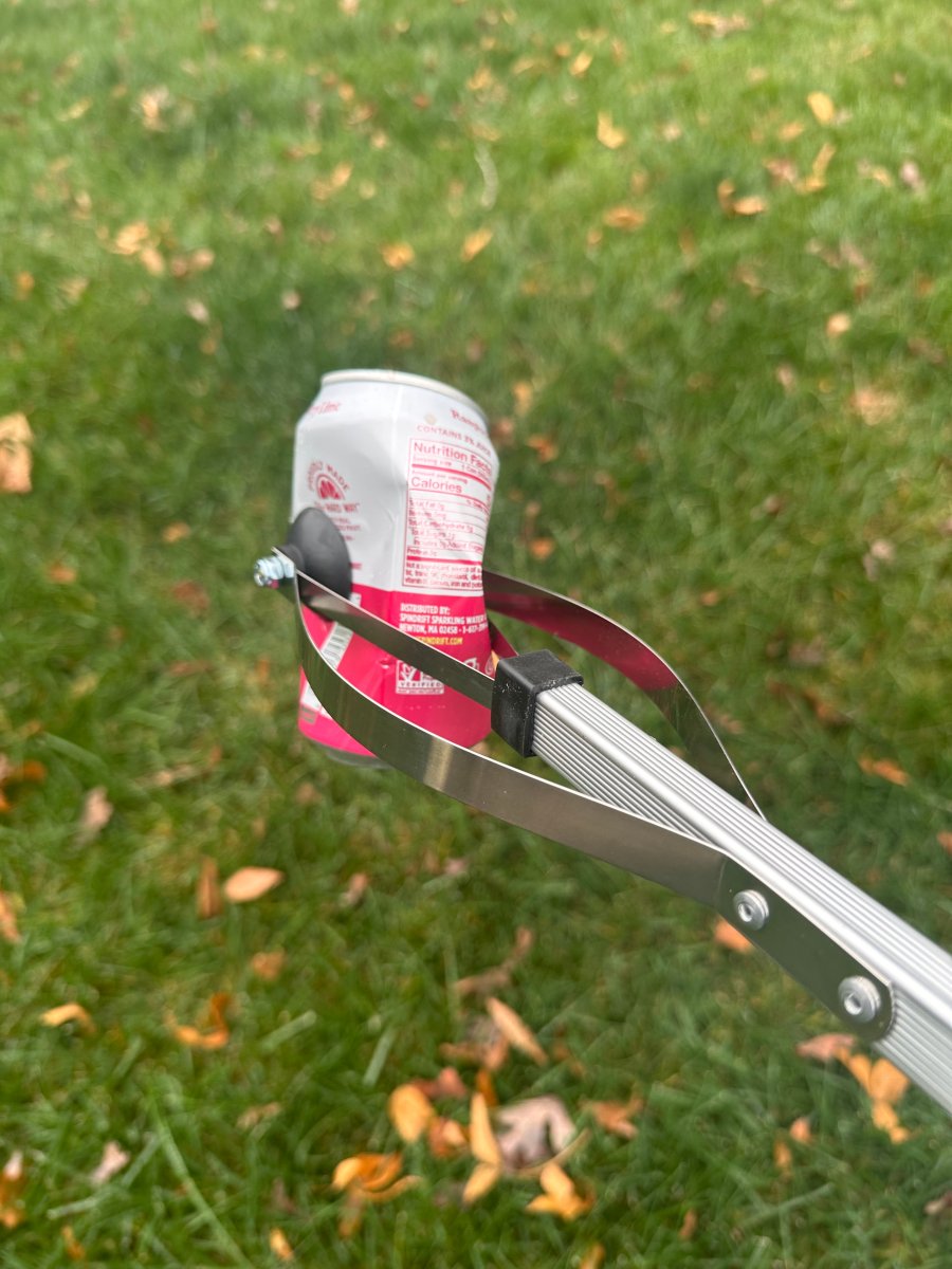Person using grabber tool to pick up garbage