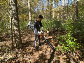 Man using leaf vacuums in a forest