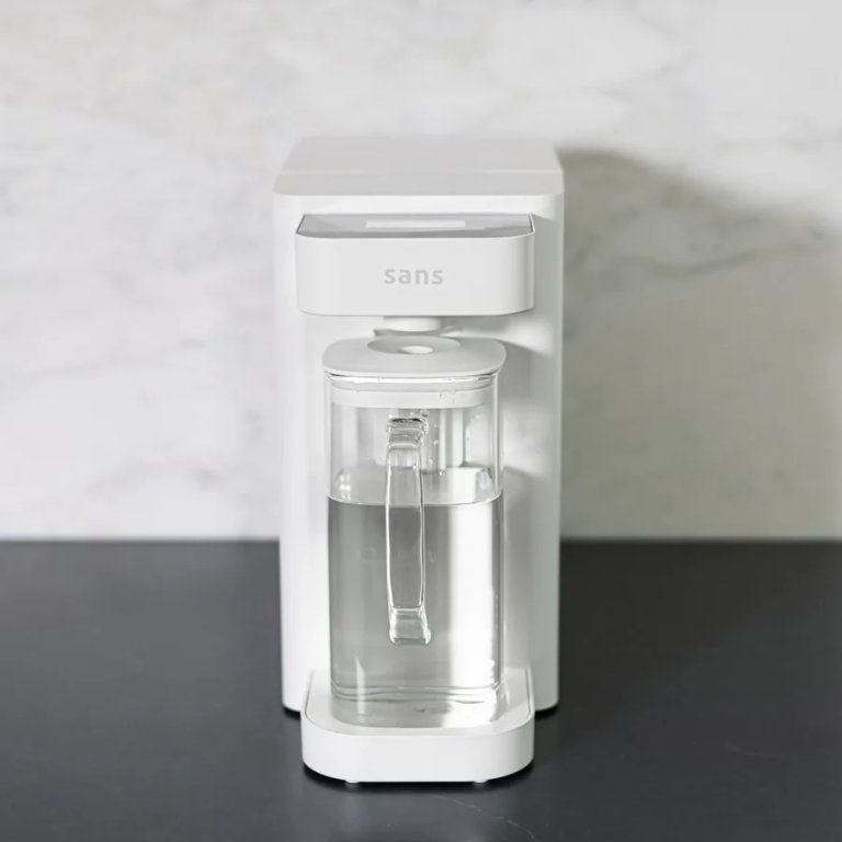 Sans Water Purifier with filled filtered pitcher out on a kitchen countertop