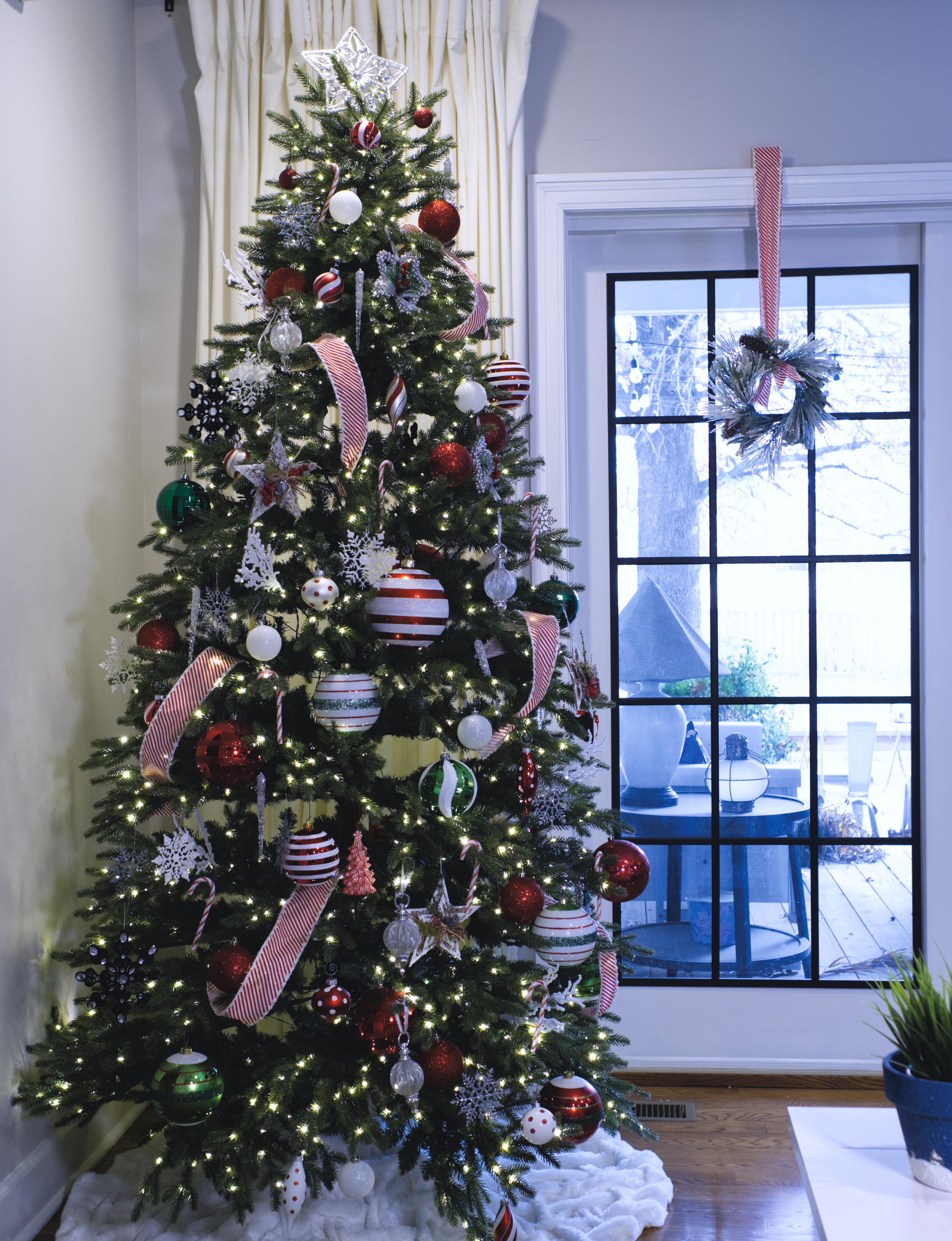 Christmas tree decorated in front of patio door
