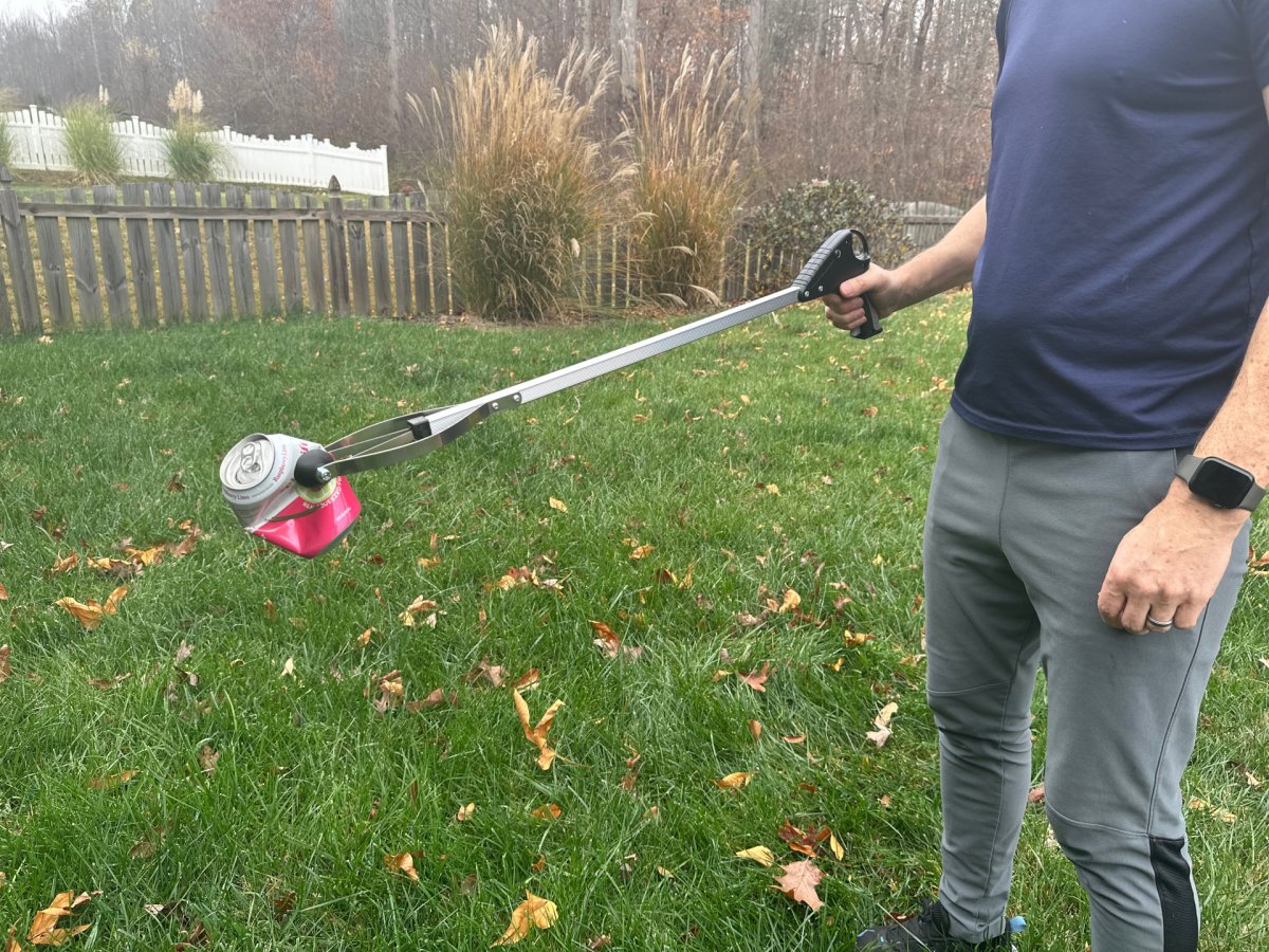 a person using grabber tool to fetch a can outside