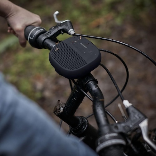 Bose Soundlink portable Bluetooth speaker attached between the handlebars on a bicycle.