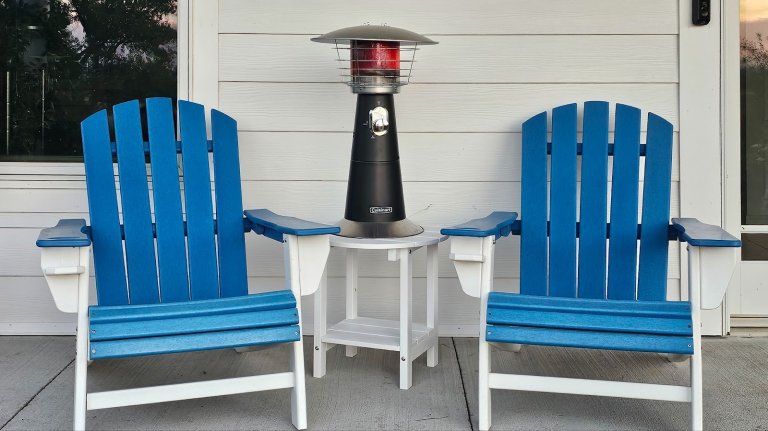 Cuisinart table top patio heater on table between two blue Adirondack chairs