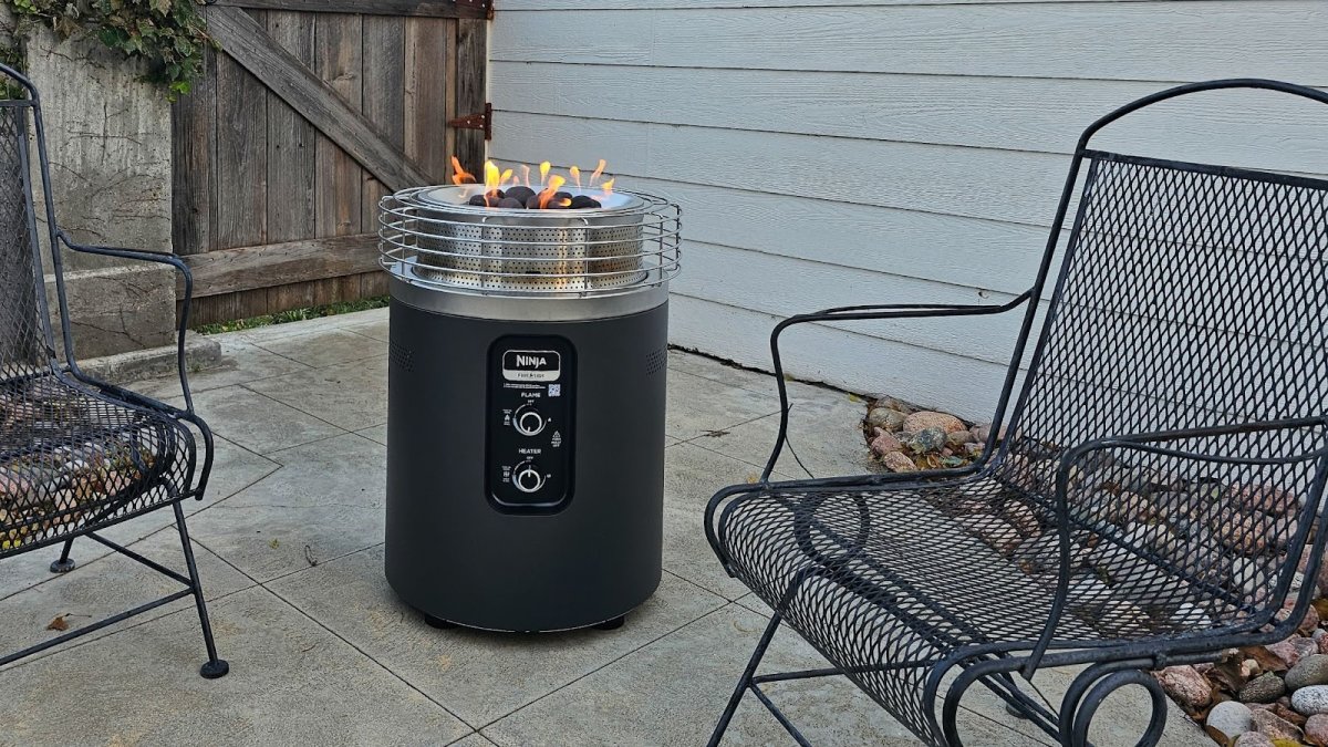 Ninja Fireside patio heater on concrete patio between black metal chairs