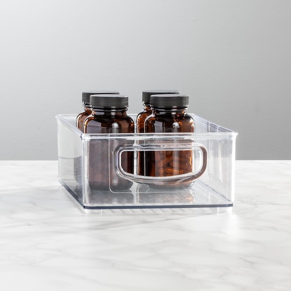 mDesign storage containers with brown glass supplement bottles inside.