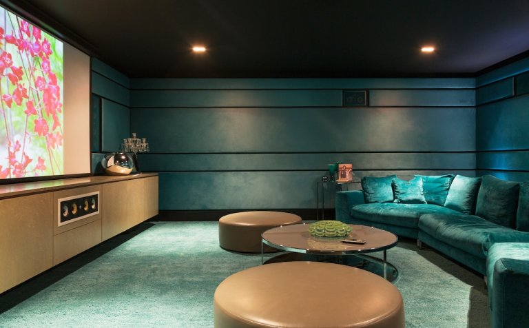 A cozy home theater with soft seating and a large screen.