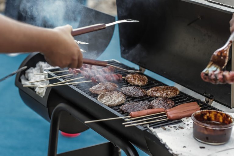 Person Grilling Sausage and Meat with grill tool sets