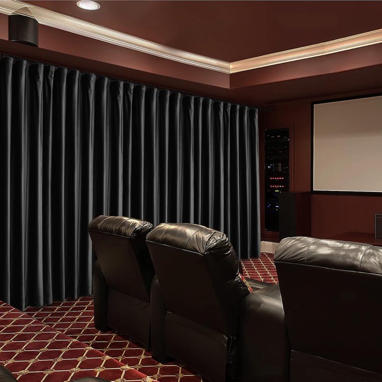 Fcosie home theater curtains in black lining one wall of a home theater with burgendy carpets and leather recliners.