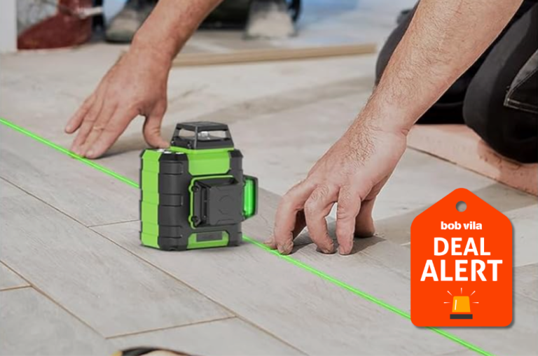 Person using Huepar laser level to install wood plank flooring