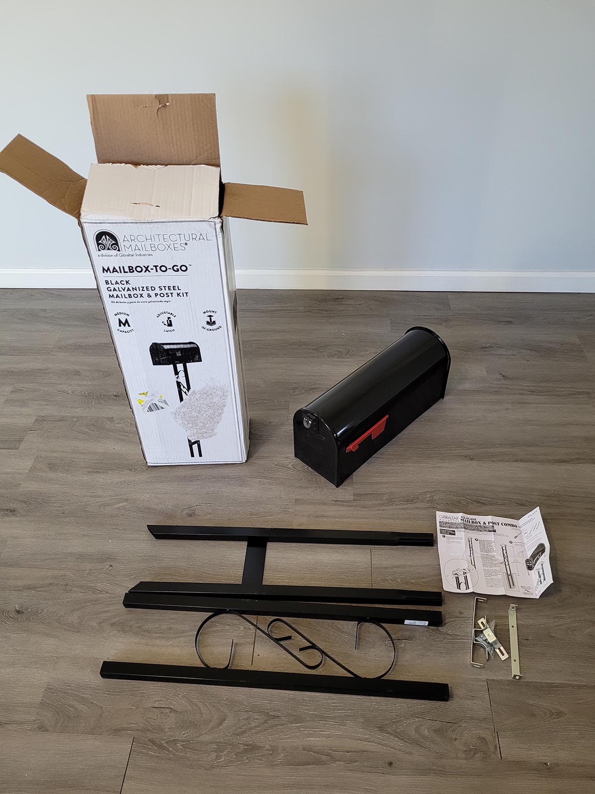 Mailbox to Go Post Kit box and contents of the box lying on the floor.