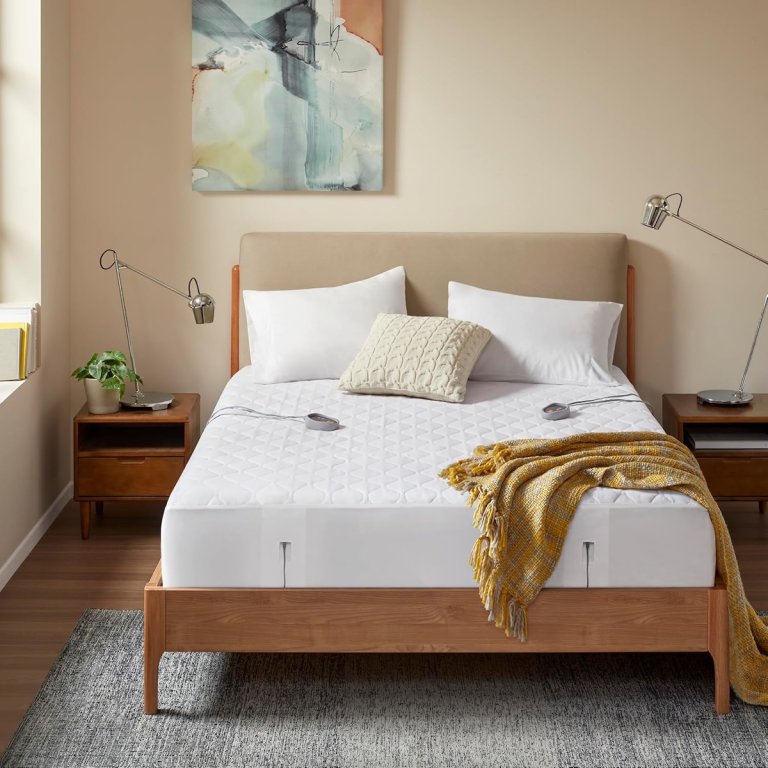 Beautyrest heated mattress pad on a low-profile, Scandinavian-style bed in neutral colored bedroom.