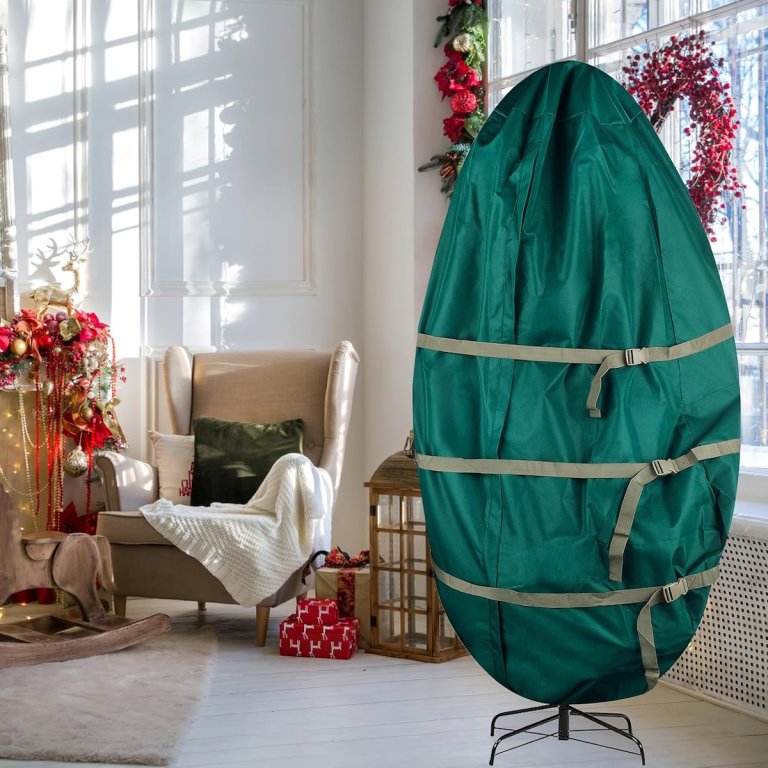 a standing Christmas tree wrapped in a large green bag with straps. A holiday living room scene in the background.