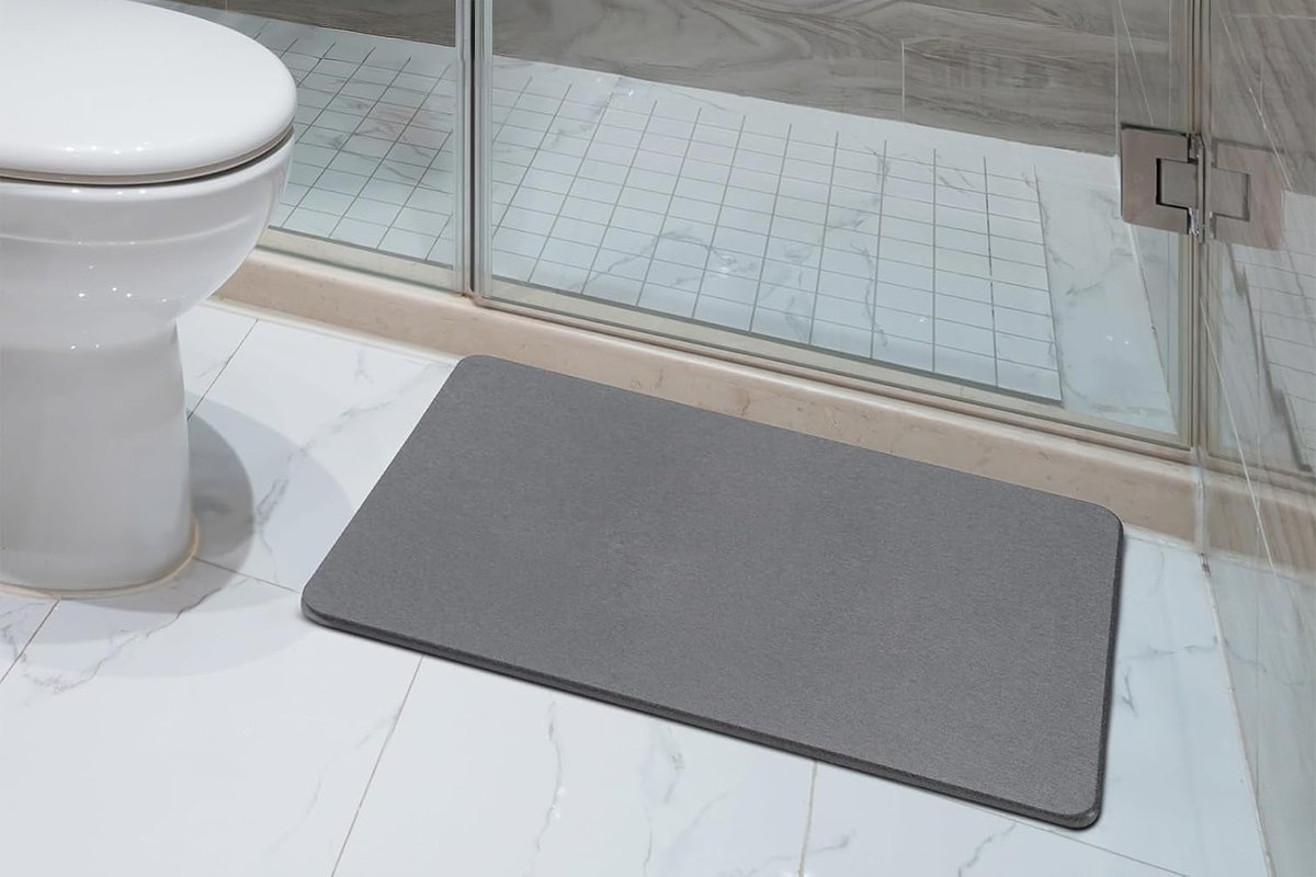 A diatomaceous earth stone bath mat outside of a shower.