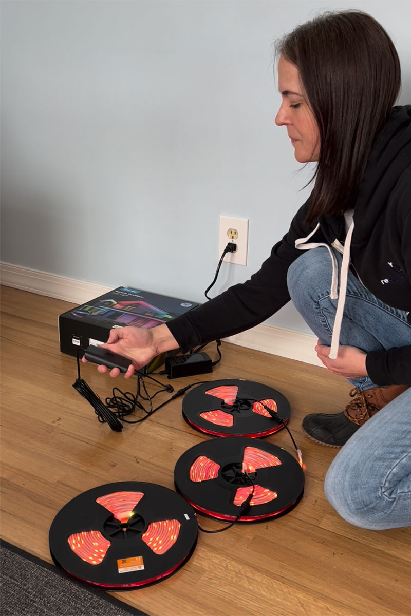 Editor Jenny Stanley plugging in Govee Outdoor Strip Lights to test that they work before installing.