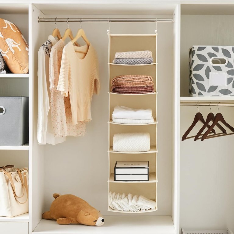 Max Houser hanging closet organizer in closet, with sweaters and clothes on the shelves.