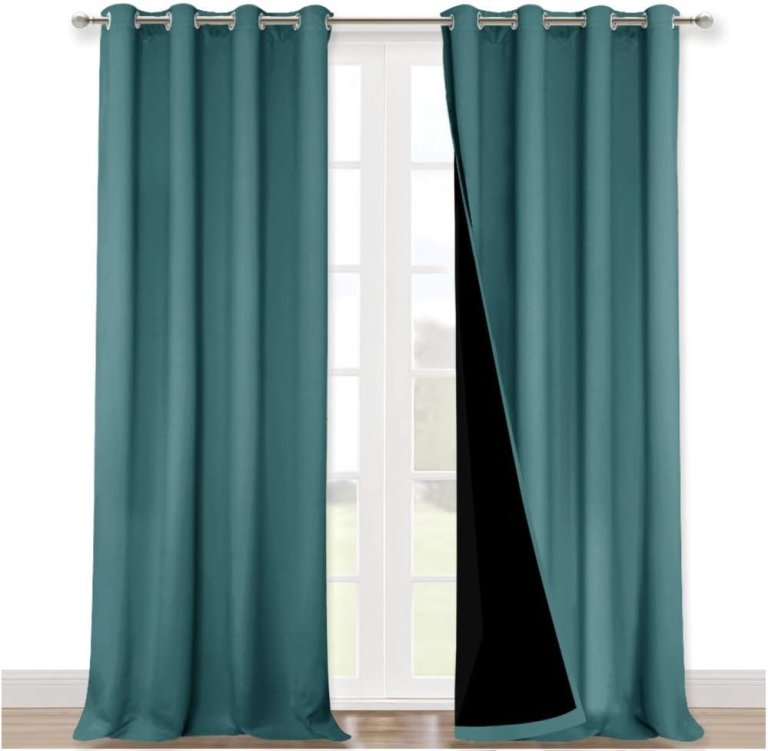 Teal pair of Nicetown curtains with black lining on a curtain rod, against a white wall.