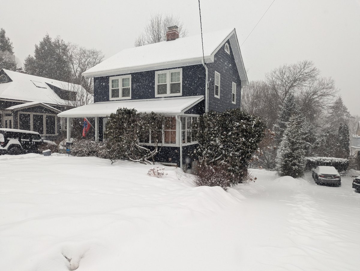 Navy blue house covered in snow from a big snowfall