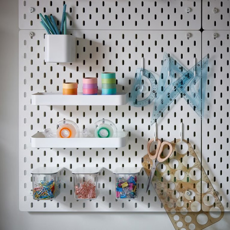 Ikea Skadis square pegboard with accessories hung to organize a deskspace