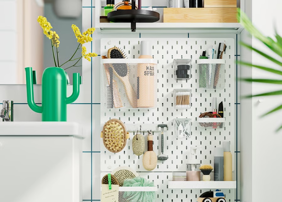 Two Ikea Skadis white pegboards hung in the bathroom to keep hygiene essentials in arm's reach, including brushes, haircare, makeup supplies, and more.