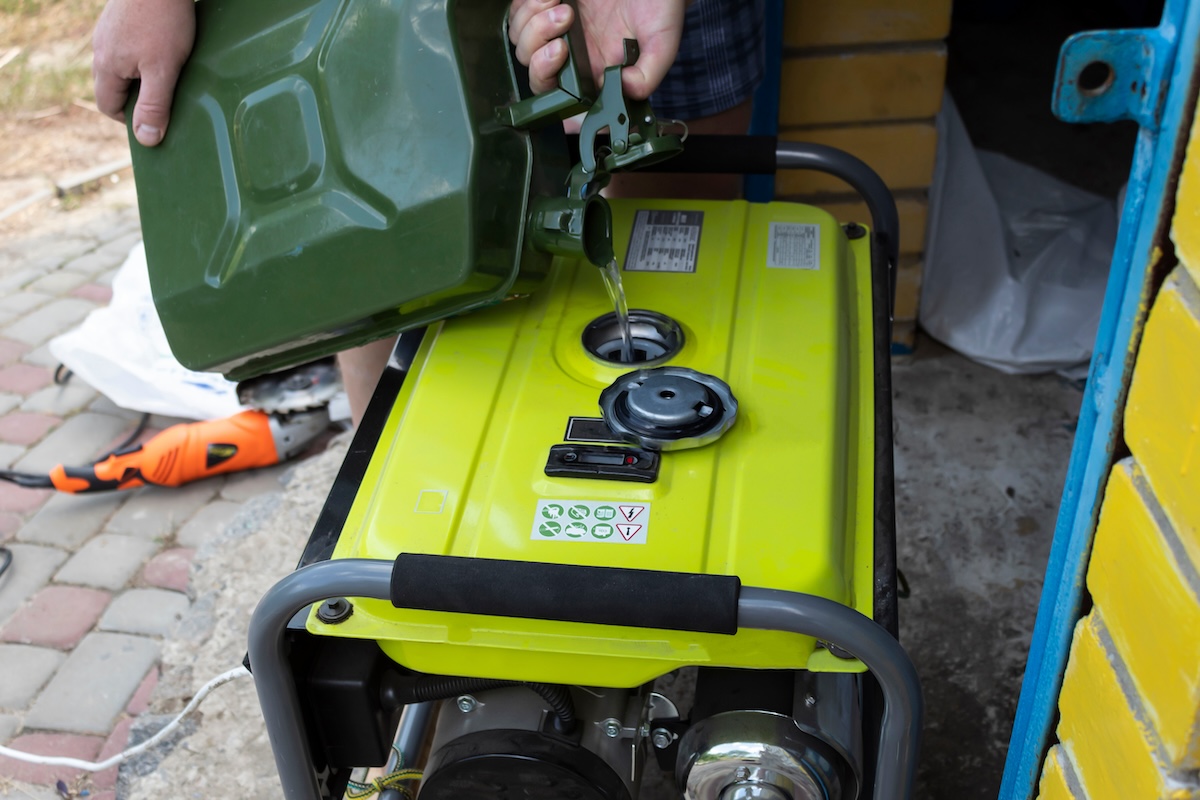 A man pours gasoline into a portable generator.