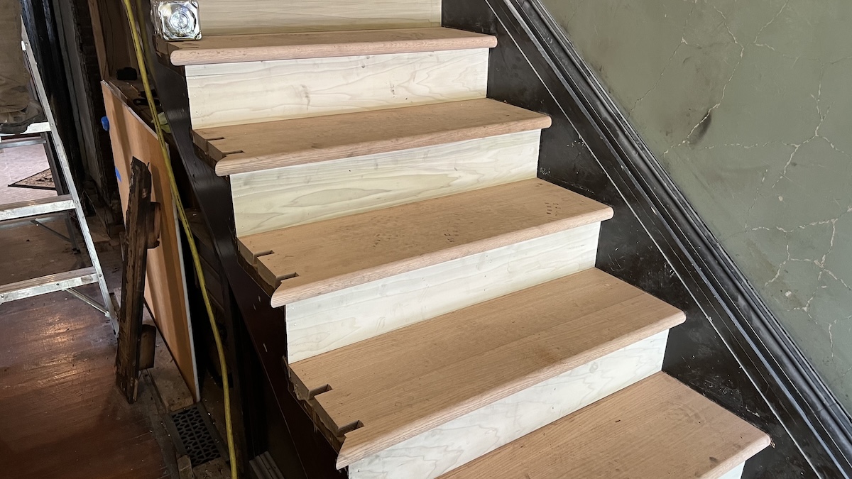 Rebuilding stairs after removing a wall and revealing old trim.