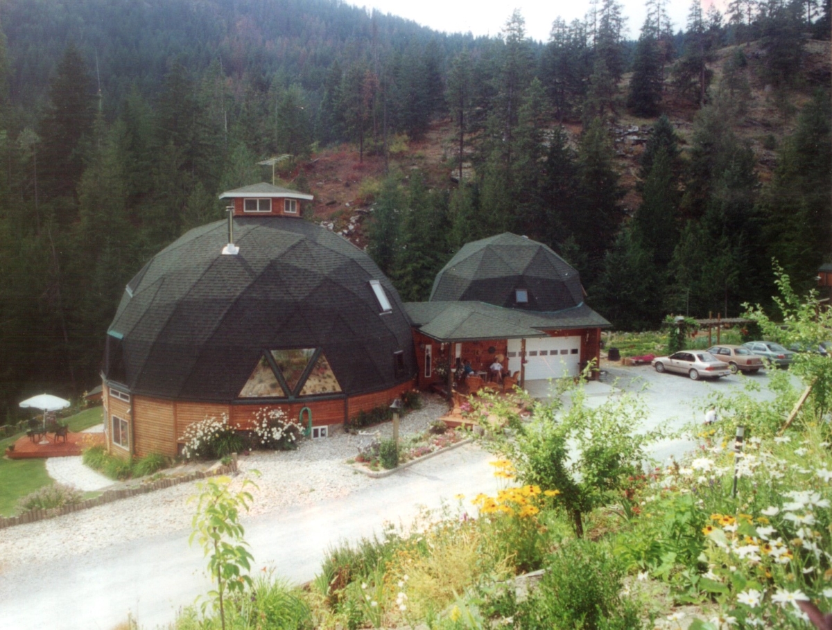 A large geodesic dome home with matching garage.
