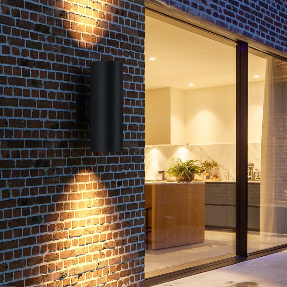 The exterior of a brick home with an accent landscape light. 