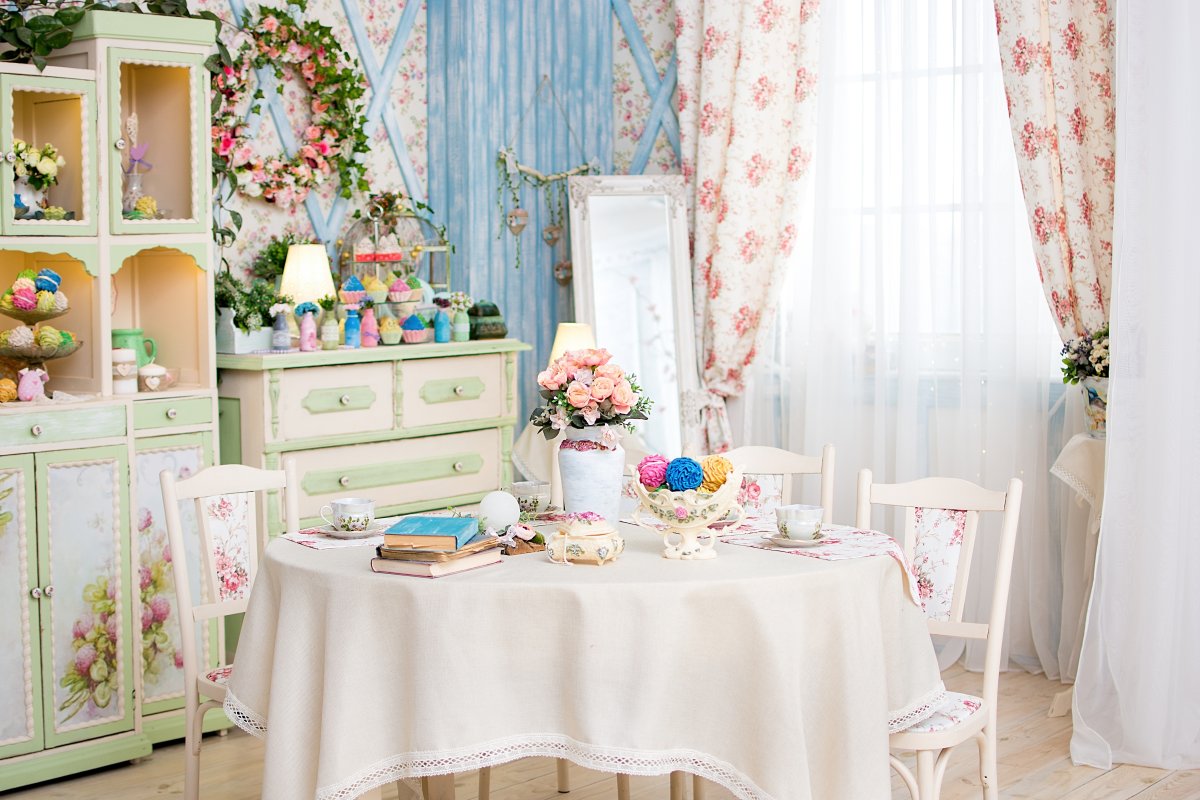 Vintage retro room interior with steel, vase of flowers, antique wardrobe, bright colorful pastries, window with colorful curtains