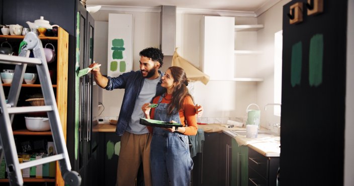 Happy couple in their kitchen working on a DIY project.