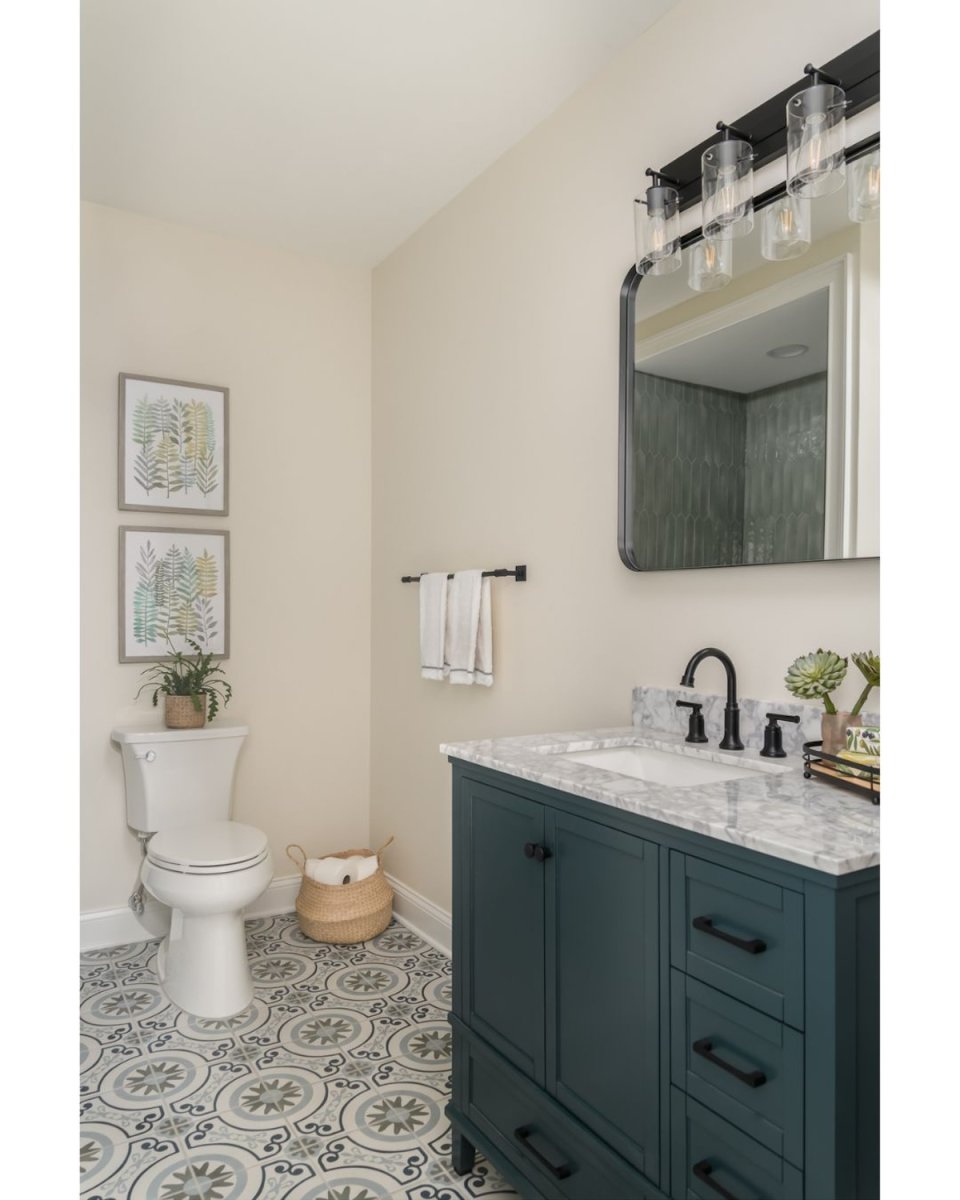 A small bathroom with a. turquoise vanity, tiled floors, and warm white walls.