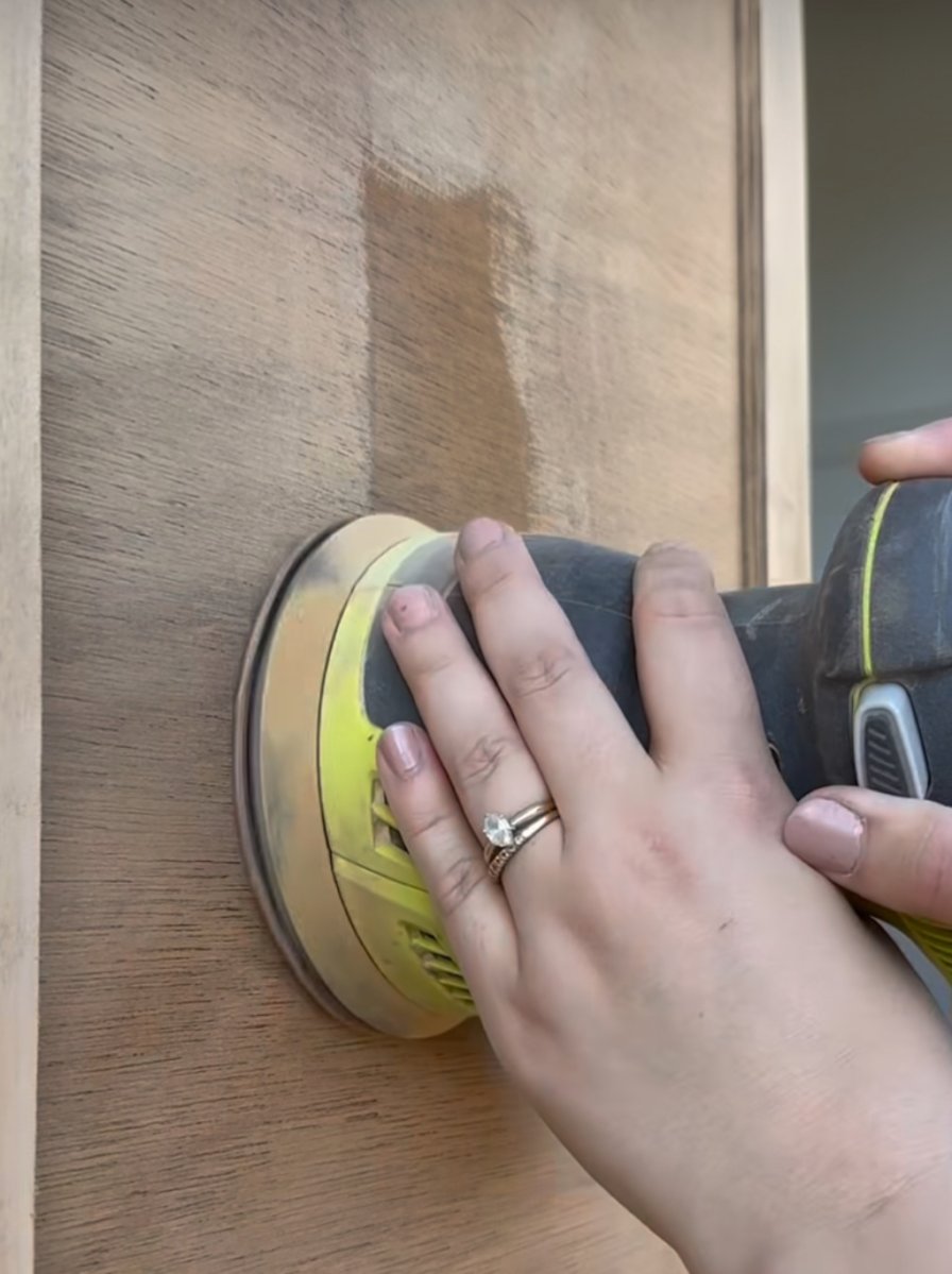 Sanding a wood dresser to restore old lighter wood color.