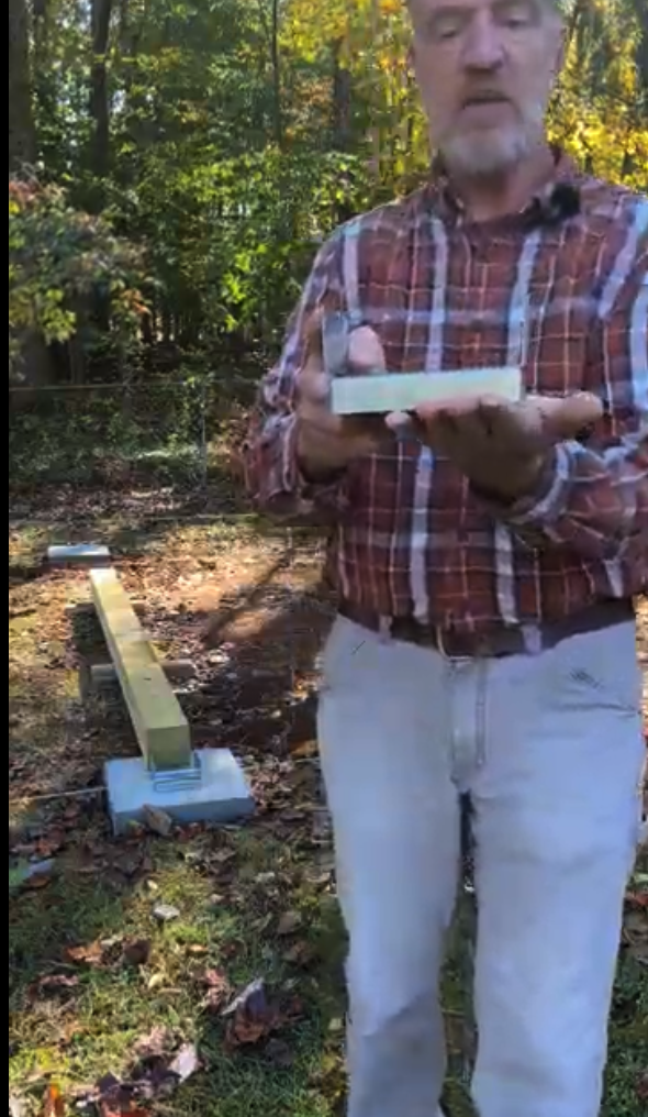 a person holding ABA ZMAX Adjustable Standoff Post Base