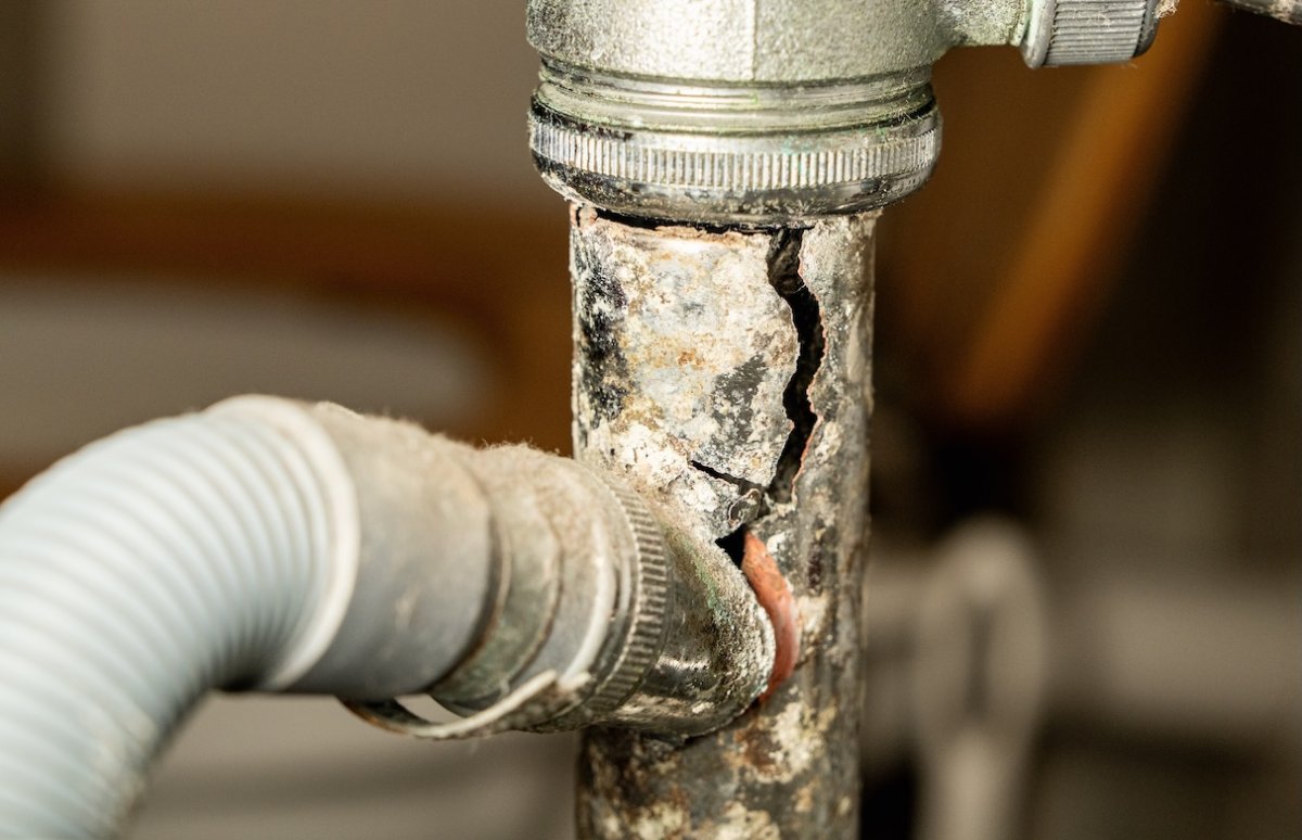 Broken drain pipe under bathroom sink, leaking water.