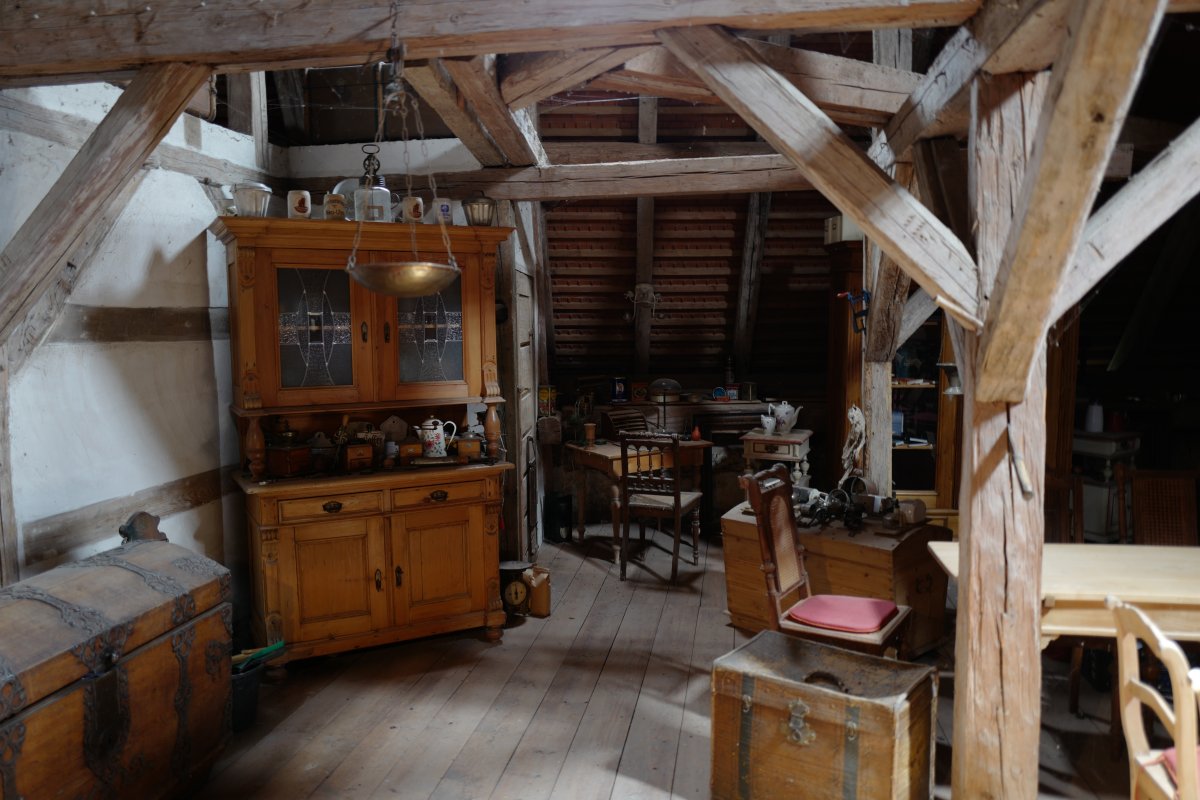 Antique wood furniture being stored in an attic.